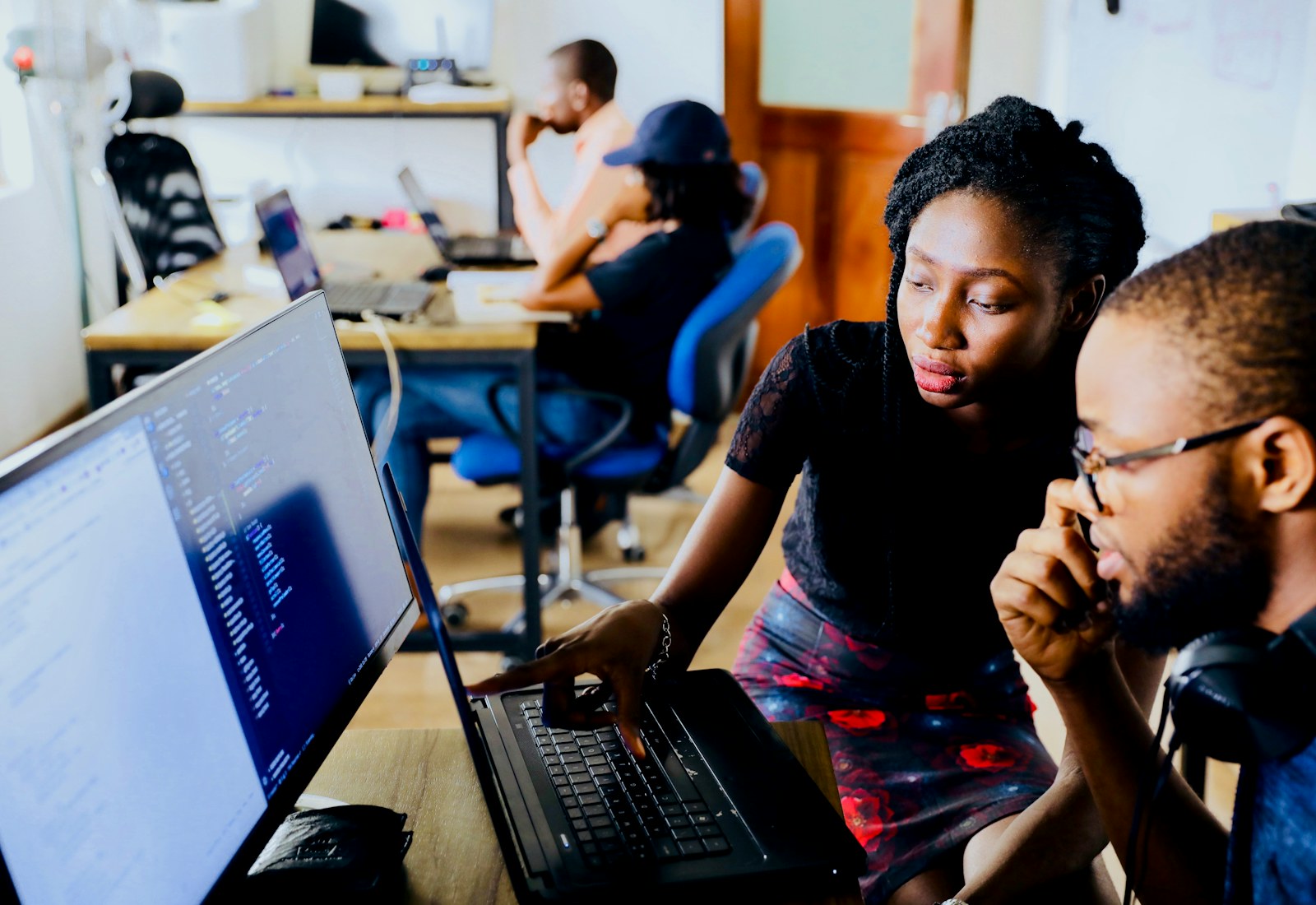 Mentor guiding a learner through code on a laptop